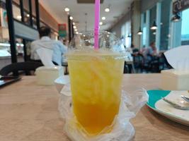 iskall krysantemumjuice på träbord i suddig kaférestaurang foto