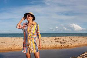 kvinna som bär färgglada strandkläder på stranden känd som pitinga, i arraial d ajuda, Bahia, Brasilien foto