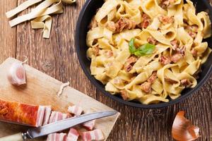 pasta carbonara med bacon, basilika och ost