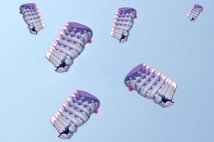 många fallskärmar över en blå himmel bakgrund foto