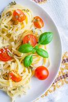 spaghetti med blåmögelost, tomater och basilika foto