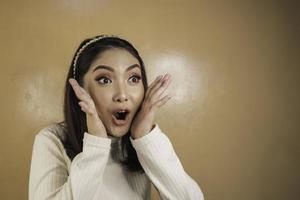 wow och chockat ansikte av ung asiatisk kvinna med öppen handgest. reklam modell koncept. foto