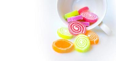färgglada godis och sockergodis på en vit bakgrund foto