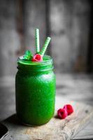 färsk grön smoothie på rustik träbakgrund foto