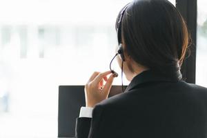 ung affärskvinna med headset och bärbar dator i en video c foto