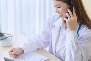 coronavirus skydd concept.female läkare ger telefonkonsultation foto