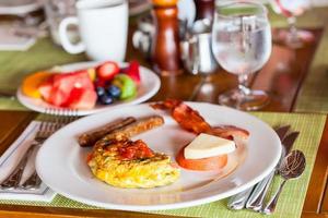frukost med omelett, färsk frukt och kaffe foto