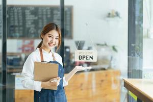 leende servitris eller café företagare entreprenör tittar på kameran foto