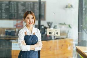 leende servitris eller café företagare entreprenör tittar på kameran foto