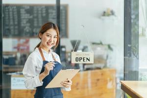 leende servitris eller café företagare entreprenör tittar på kameran foto