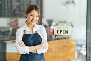 leende servitris eller café företagare entreprenör tittar på kameran foto