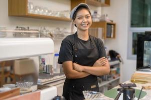 ung serviceinriktad baristakvinna som arbetar i kafé foto