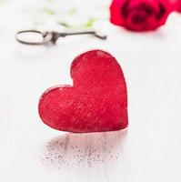 stort rött trähjärta över ros och nyckel, alla hjärtans dag foto