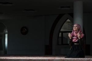 ung muslimsk kvinna som ber i moskén