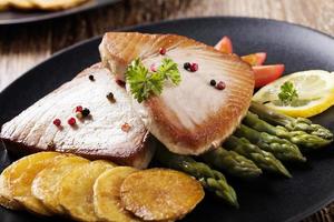 grillad tonfiskbiff serverad på sparris med rostad zmieniakami foto