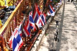 rad av angklung med flagga är på golvet bredvid gatan, musikinstrument förbereds innan show i thailand. foto