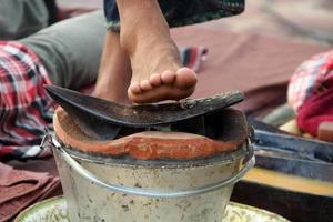 järn plog plattan är på lera eld potten och oskärpa foten ovanför plog plattan. förberedelseutrustning set för thaimassage i norrländsk stil. foto