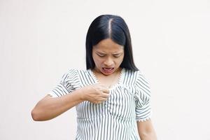 asiatiska kvinnor tittar på sina bröst och är chockade. foto