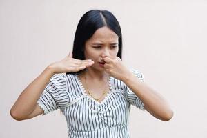 asiatiska kvinnor täcker näsan med händerna för att de luktar illa. foto