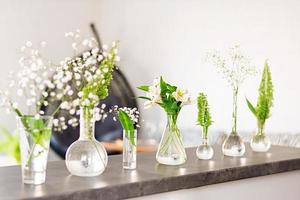 vackra vårblommor i vaser på ljus bakgrund foto