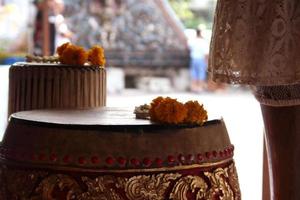 thai forntida trumma och blomsterkrans på den. yta av trumma gjord av koläder, thailand. foto