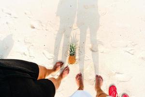 sommarstrandsemester med ananas och flip flops på stranden foto