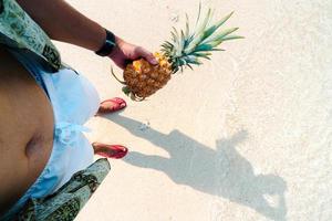 sommarstrandsemester med ananas och flip flops på stranden foto