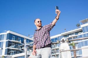 ung skäggig man gör selfie på telefonen foto