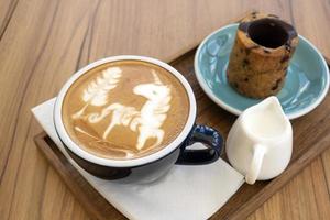 varm latte med kakor på ett träbord foto