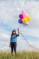 vacker flicka hoppar med ballonger på stranden foto