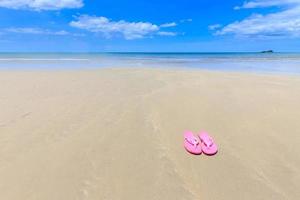 rosa sandaler på den vackra stranden foto