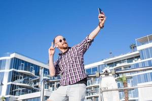 ung skäggig man gör selfie på telefonen foto