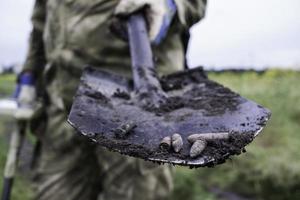 soldat som använder en metalldetektor i fält foto