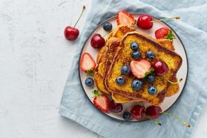 french toasts med bär, brioche frukost, vit bakgrund ovanifrån kopia utrymme foto