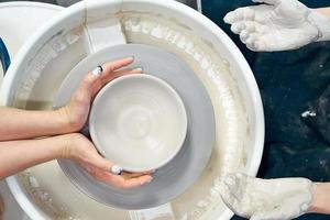 kvinna gör keramik keramik på hjul, händer närbild. koncept för kvinna i frilans foto