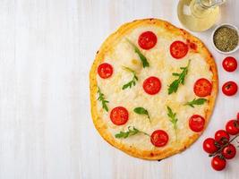 varm hemlagad italiensk pizza margherita med mozzarella och tomater foto