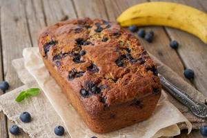 bananbröd på gamla mörka rustika träbord, tårtskiva med banan, närbild foto