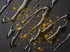 mörk mat bakgrund med curry kryddor och olja på fluoroplastisk stekpanna, makro, närbild foto