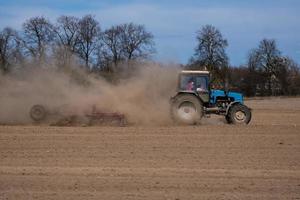 traktor som plöjer fältet. lantbruk. markodling foto