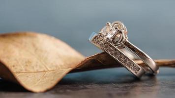 närbild av en diamantförlovningsring placerad på ett löv. kärlek och bröllop koncept. foto