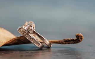 närbild av en diamantförlovningsring placerad på ett löv. kärlek och bröllop koncept. foto