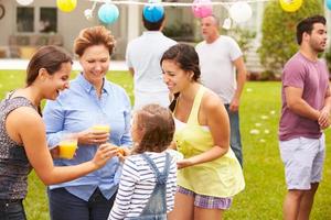 multi generation familj njuter av fest i trädgården tillsammans