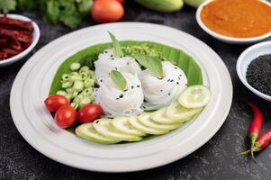 nudlar i ett bananblad med vackert lagda grönsaker och tillbehör. Thai mat. foto