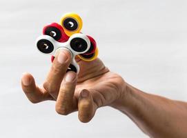 hand som håller spinner, gul-röd. foto