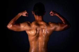 en stark asiatisk man höjde sina armar för att visa sina starka och vackra muskler från träning foto