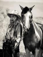 en ung cowgirl står med en pistol för att skydda lägrets säkerhet i det västra området foto