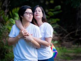 Asiatiska homosexuella par har en hbt-symbol och omfamnar varandra med kärlek och lycka foto