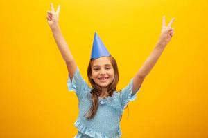 söt liten flicka firar födelsedag. närbild porträtt på gul bakgrund. foto