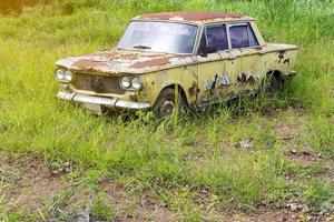gammal grön bil med gräs. foto