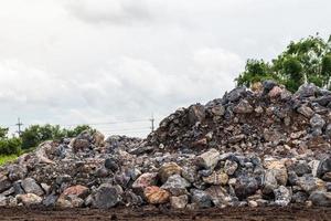 många stenblock av granit ligger på marken på landsbygden. foto